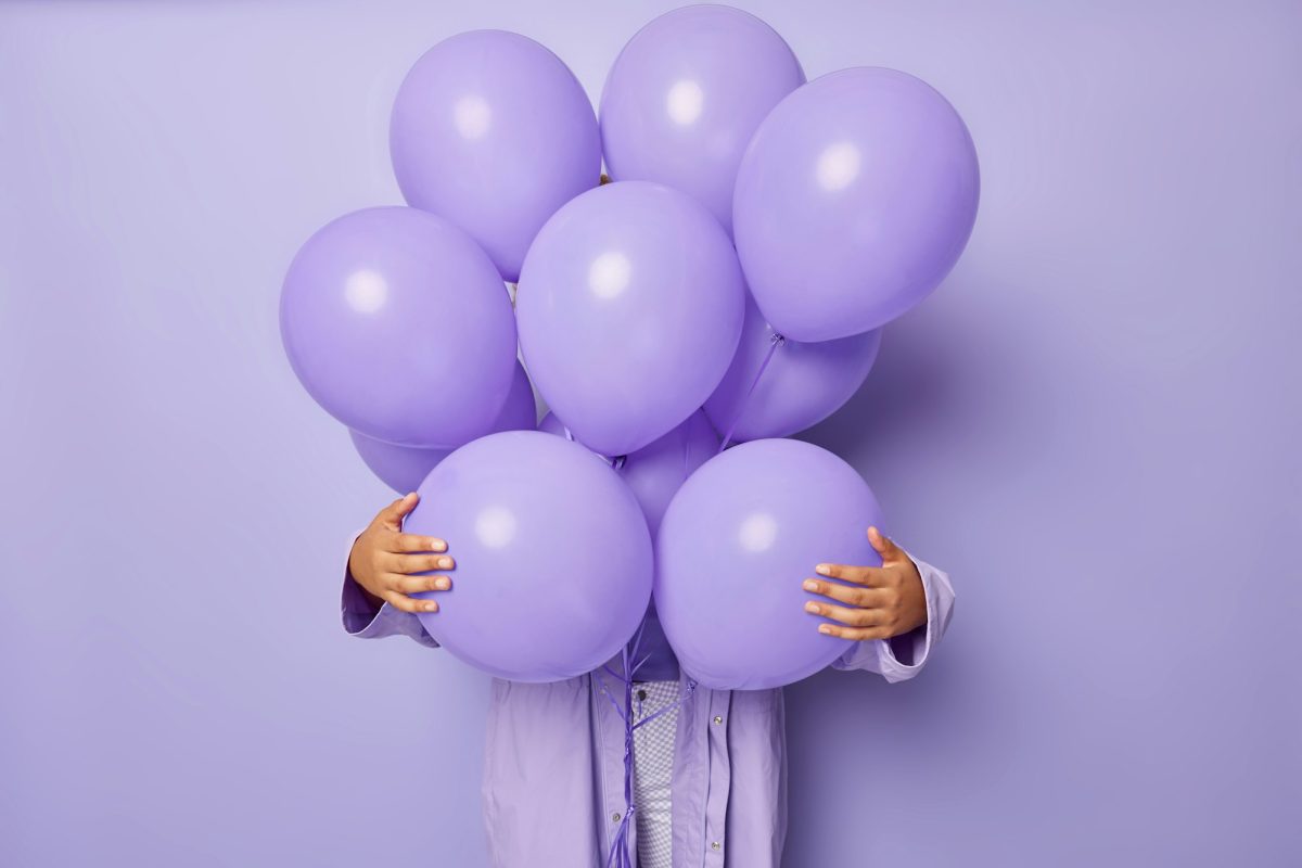 Faceless woman hides behind bunch of balloons celebrates special occasion prepares decoration for pa